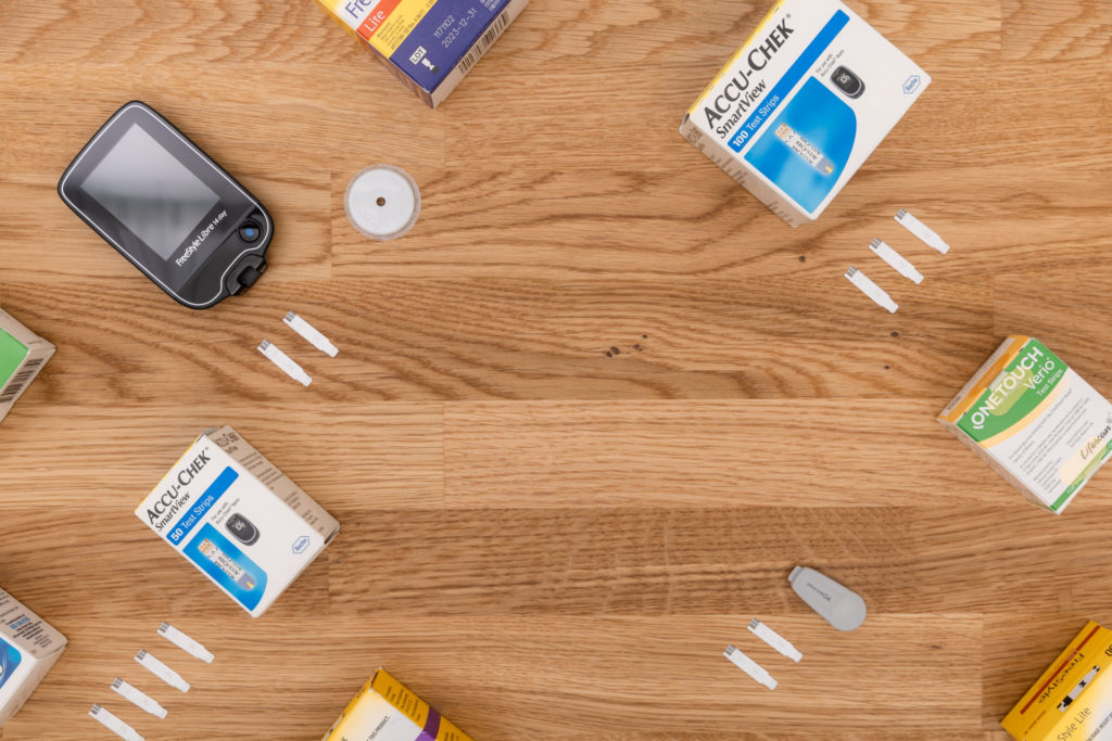 packages laid out on a wooden table to get cash for diabetic test strips
