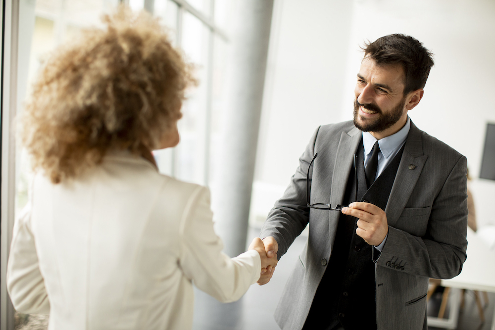 two young professionals happily shake hands after selling diabetic test strips