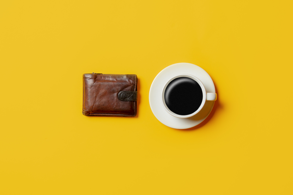 A brown wallet and a cup of coffee pictured after you sell freestyle libre 2 supplies